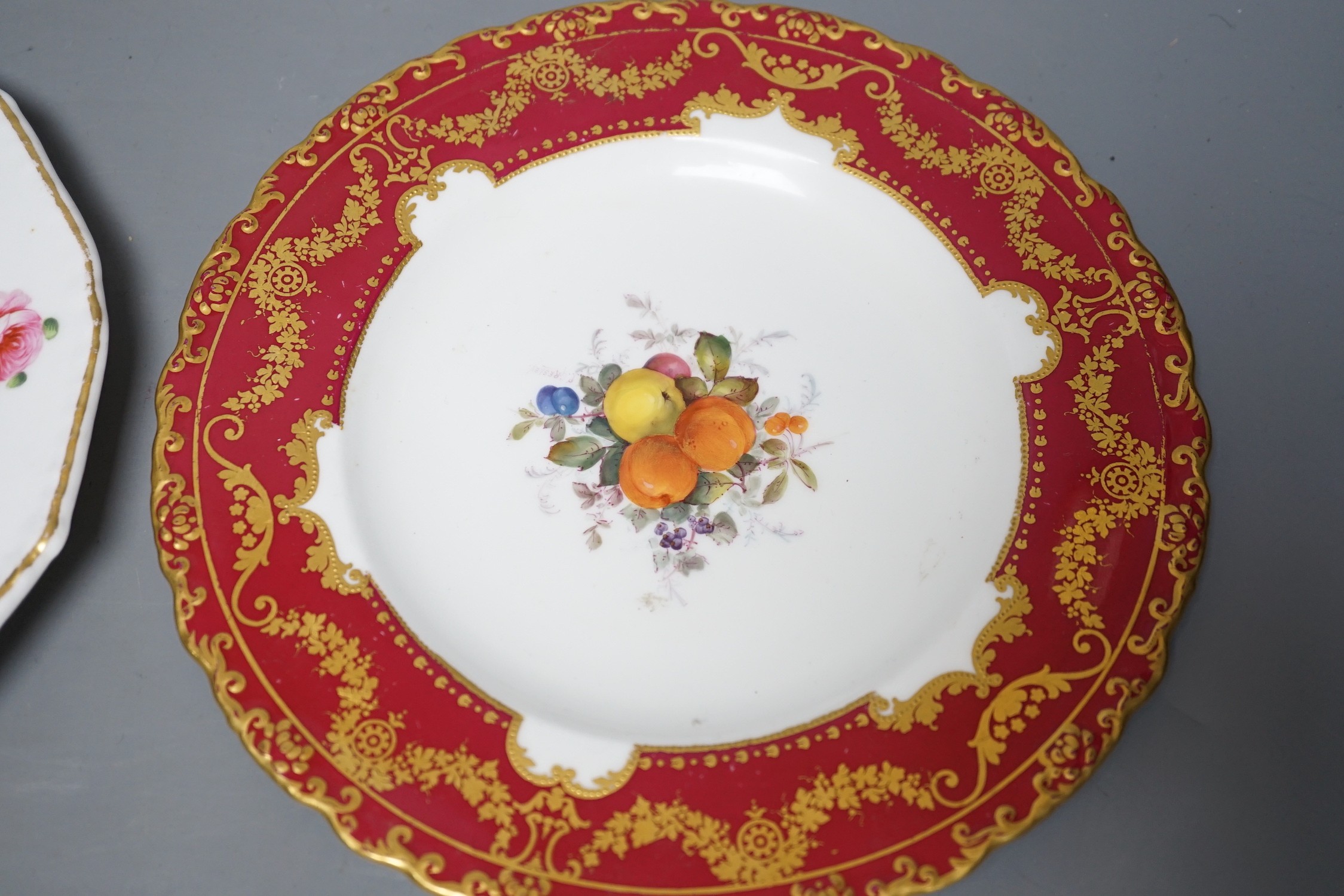 A Royal Crown Derby plate painted with fruit under claret ground by Cuthbert Gresley, signed, Made for Osler London, and a Derby King Street plate with roses